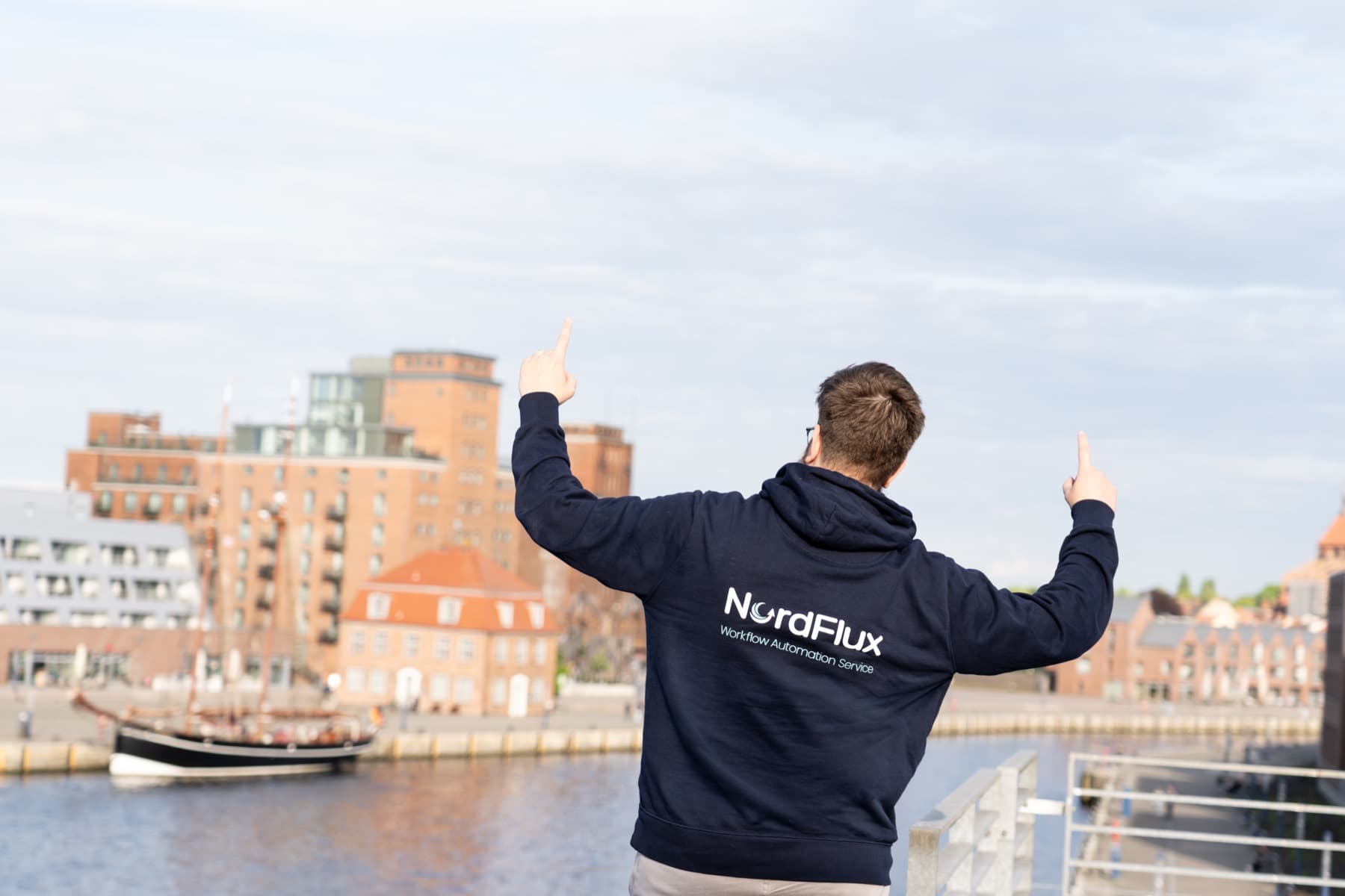 Simon Glowik im NordFlux-Hoodie mit Blick auf den Wismarer Hafen